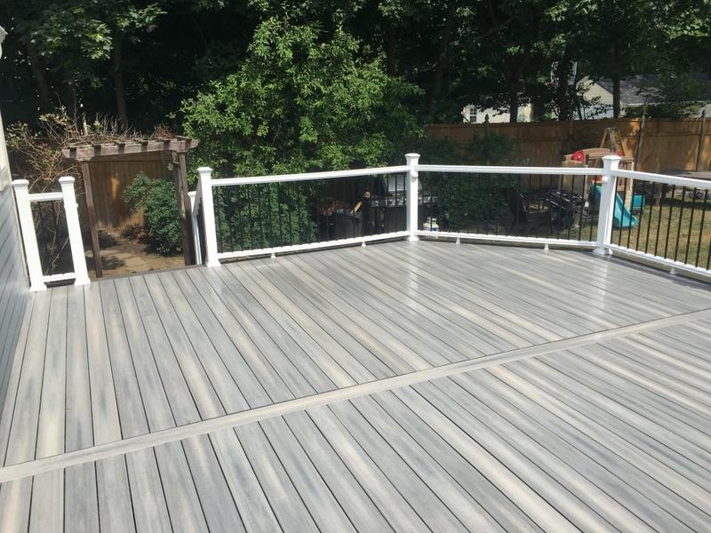 Finished composite deck with white railing in Spokane, WA, viewed from the yard
